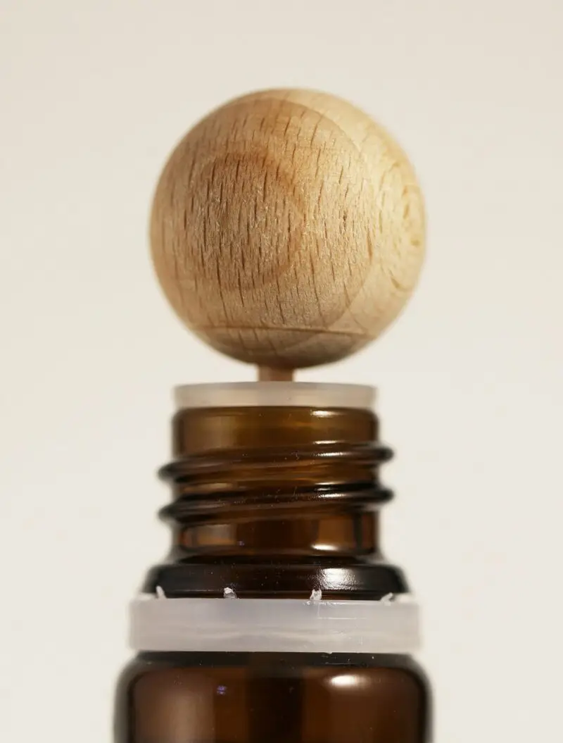 Bouchon diffuseur en bois installé sur un flacon d’huile essentielle